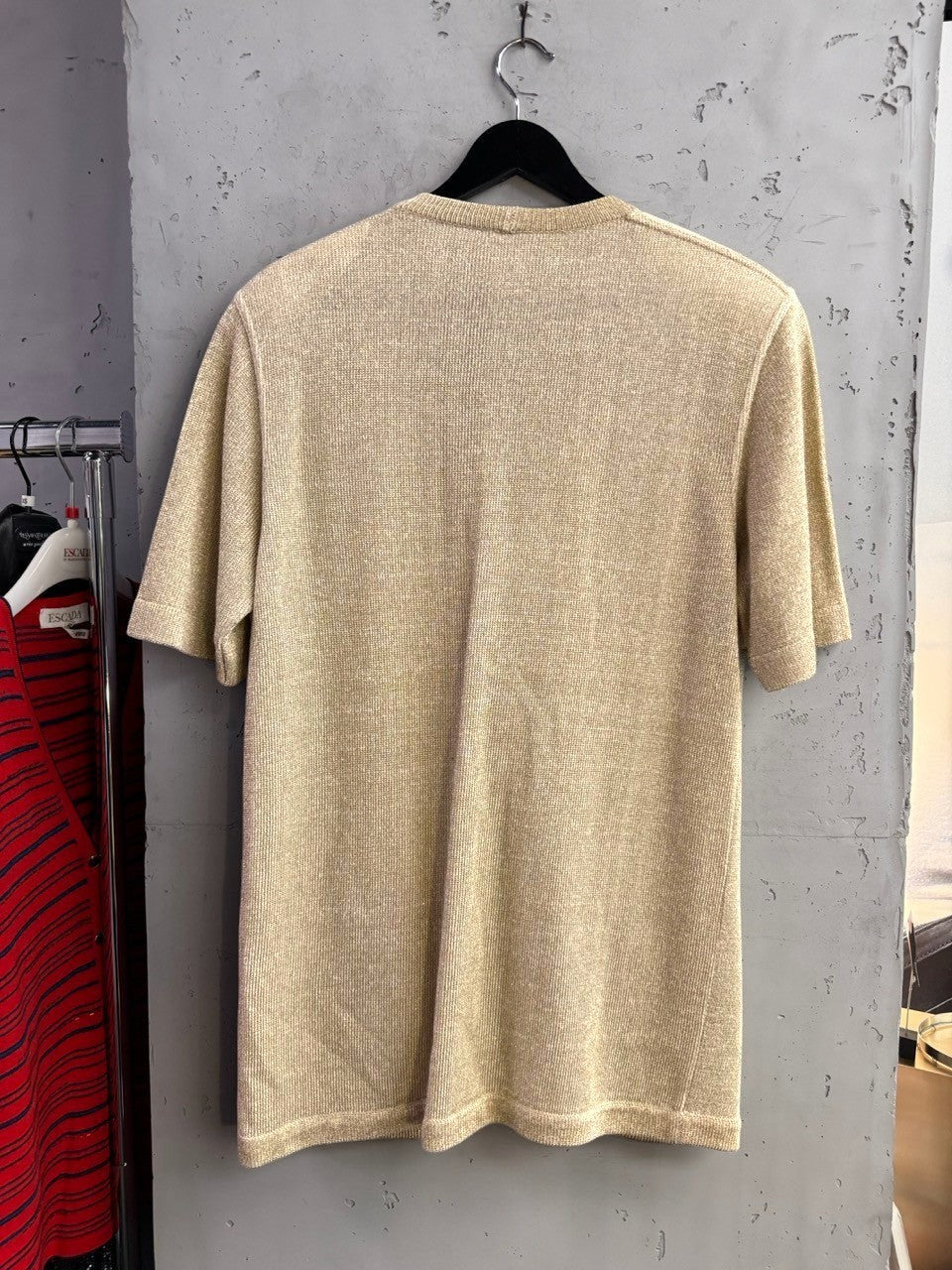 BERLIN VINTAGE CORNER Louis Féraud vintage metallic gold short-sleeve knit cardigan hanging on a black hanger.