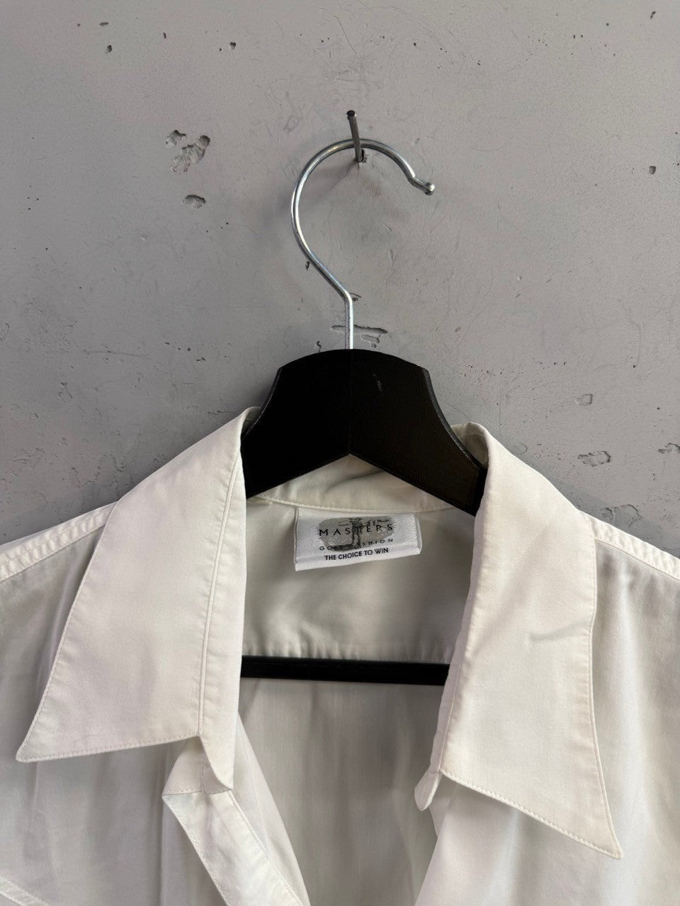 BERLIN VINTAGE CORNER white sleeveless collared golf shirt with Masters Golf Fashion label on a black hanger.