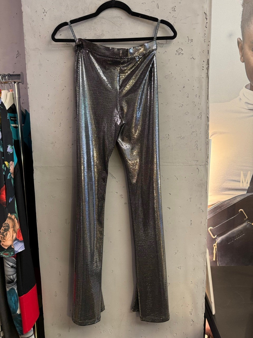 BERLIN VINTAGE CORNER metallic silver high-waisted trousers with a shimmering finish hanging on a hanger