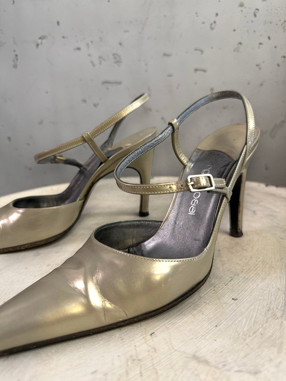 BERLIN VINTAGE CORNER metallic taupe leather pointed toe slingback heels with ankle straps and buckle closure.