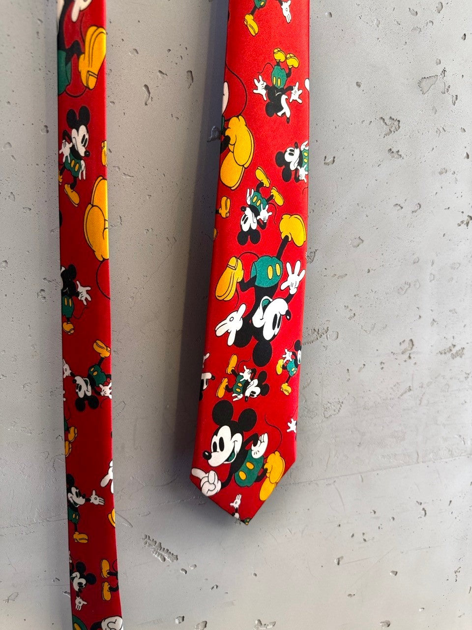 BERLIN VINTAGE CORNER red necktie with repeating Mickey Mouse print in yellow and green. Smooth fabric.