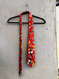 BERLIN VINTAGE CORNER red necktie with all-over Mickey Mouse print in yellow and green. Smooth fabric, standard width.