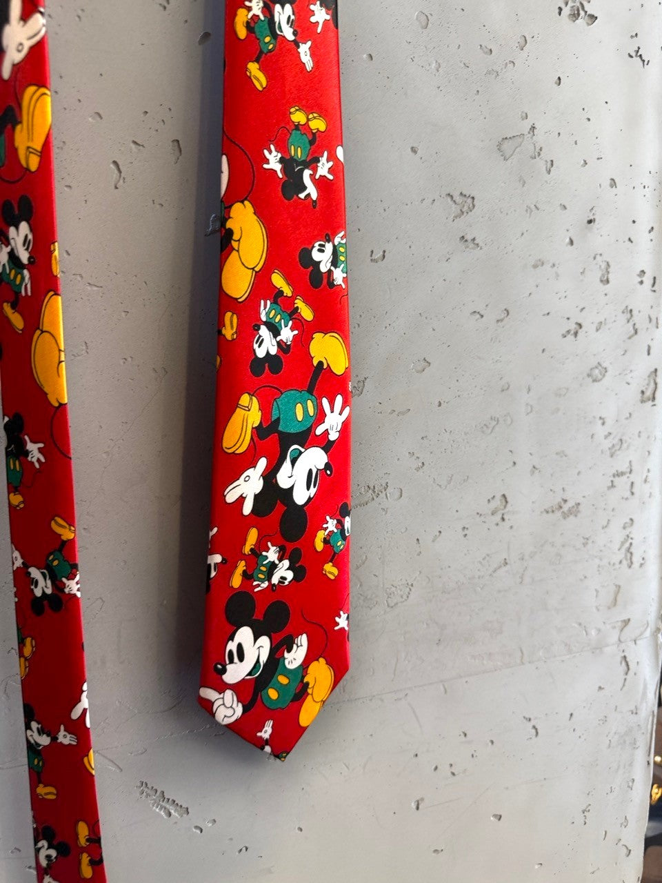 BERLIN VINTAGE CORNER red necktie with a repeating print of Mickey Mouse in yellow, green, and white. Officially licensed Disney.