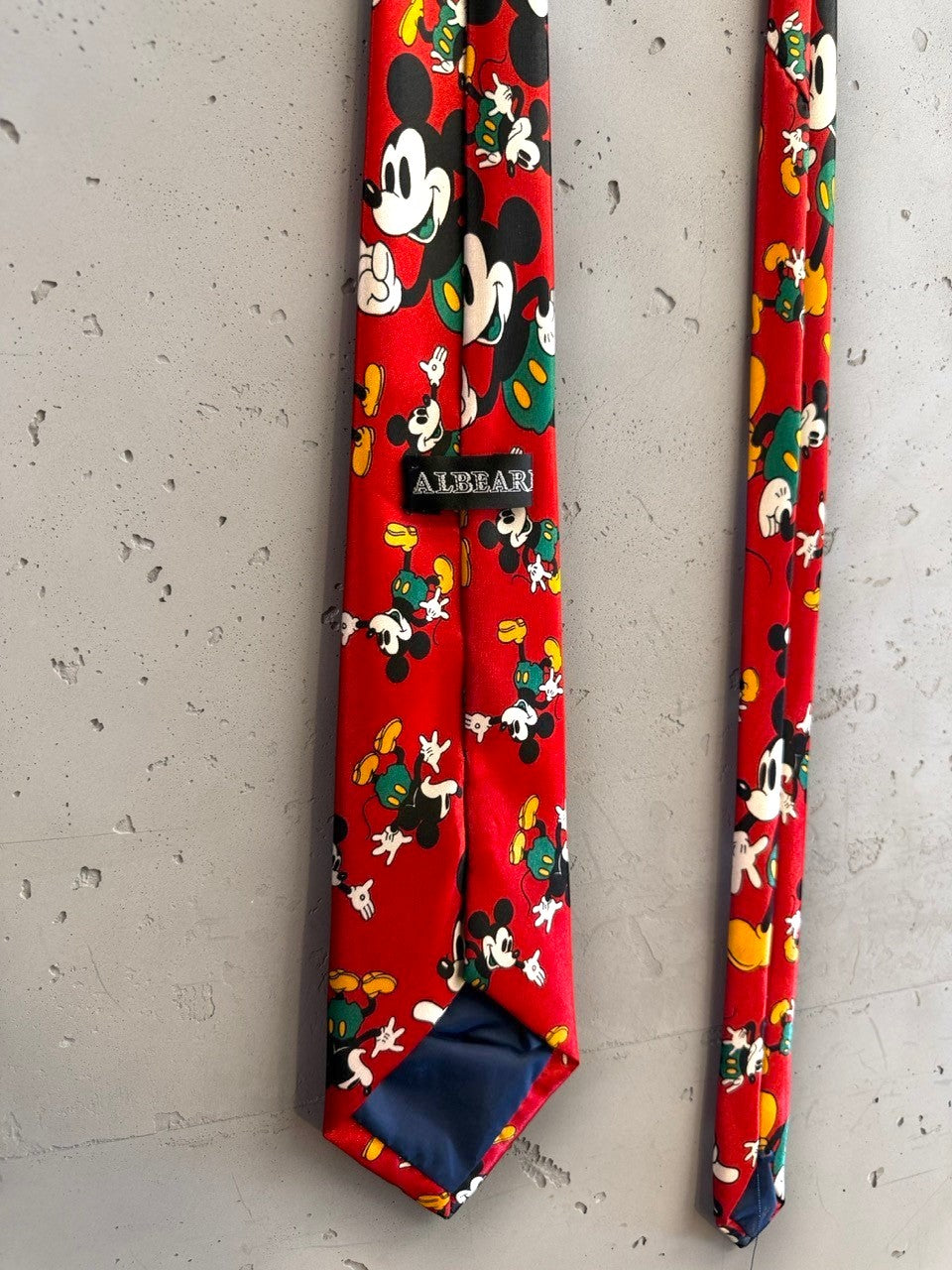 BERLIN VINTAGE CORNER red necktie with repeating Mickey Mouse print in yellow and green. Smooth fabric.