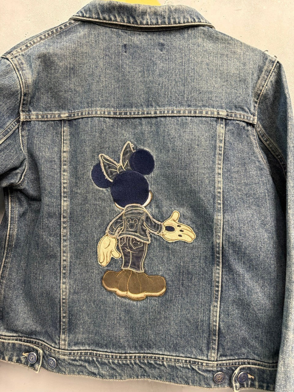 BERLIN VINTAGE CORNER blue denim jacket with embroidered Minnie Mouse graphic on back. Classic trucker style with button front.