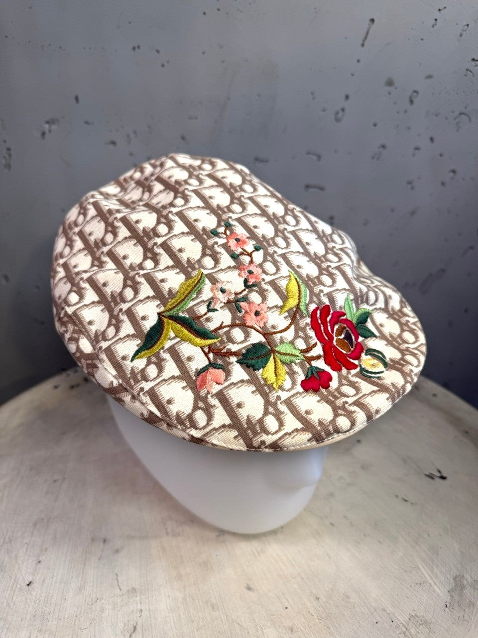 BERLIN VINTAGE CORNER beige and brown monogram canvas flat cap with vibrant floral embroidery on a mannequin head.