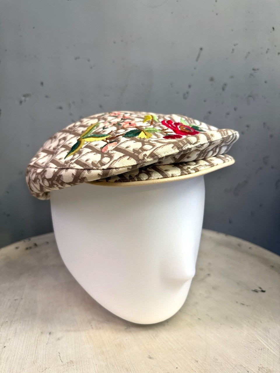 BERLIN VINTAGE CORNER beige monogram flat cap with vibrant floral embroidery on a white mannequin head