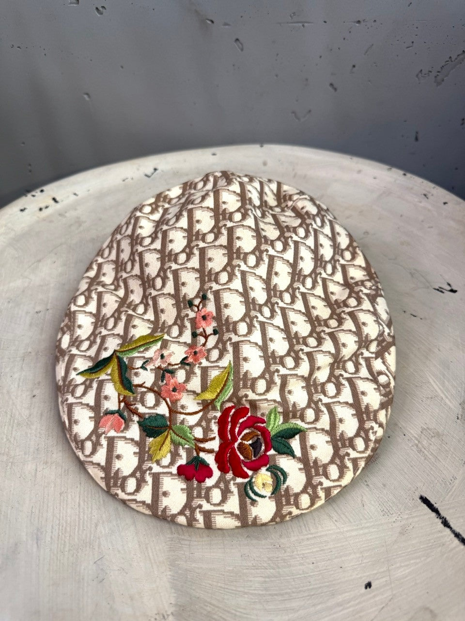 BERLIN VINTAGE CORNER beige canvas flat cap with brown monogram print and vibrant floral embroidery detailing.