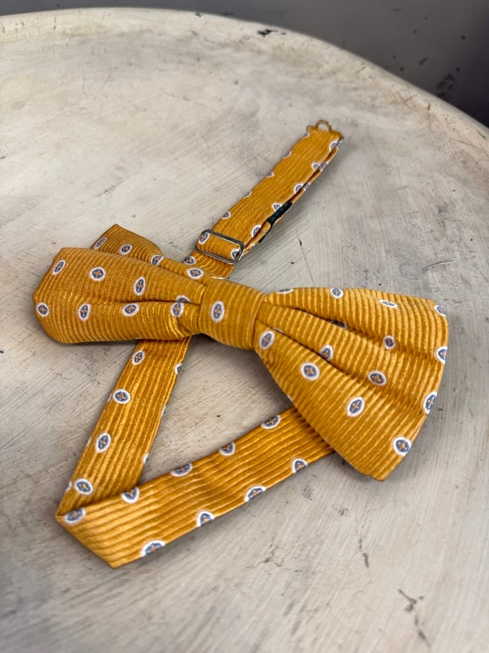 BERLIN VINTAGE CORNER mustard yellow corduroy bow tie with blue and white oval pattern, pre-tied with adjustable strap.