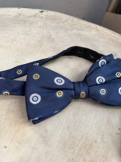 BERLIN VINTAGE CORNER navy blue bow tie with white and gold concentric circle pattern. Pre-tied with adjustable strap.