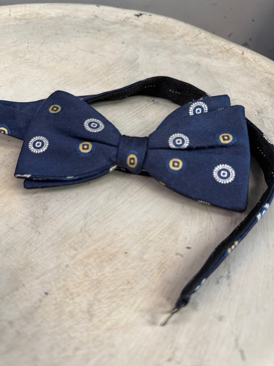 BERLIN VINTAGE CORNER navy blue pre-tied bow tie with white and gold concentric circle pattern. Adjustable strap.