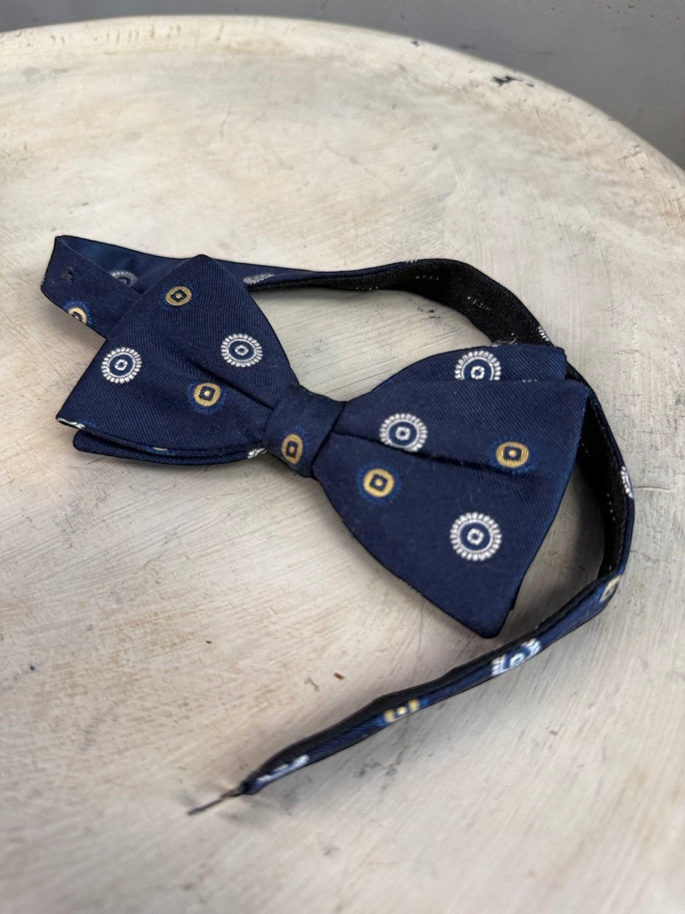 BERLIN VINTAGE CORNER navy blue pre-tied bow tie with white and gold concentric circle pattern. Adjustable strap.