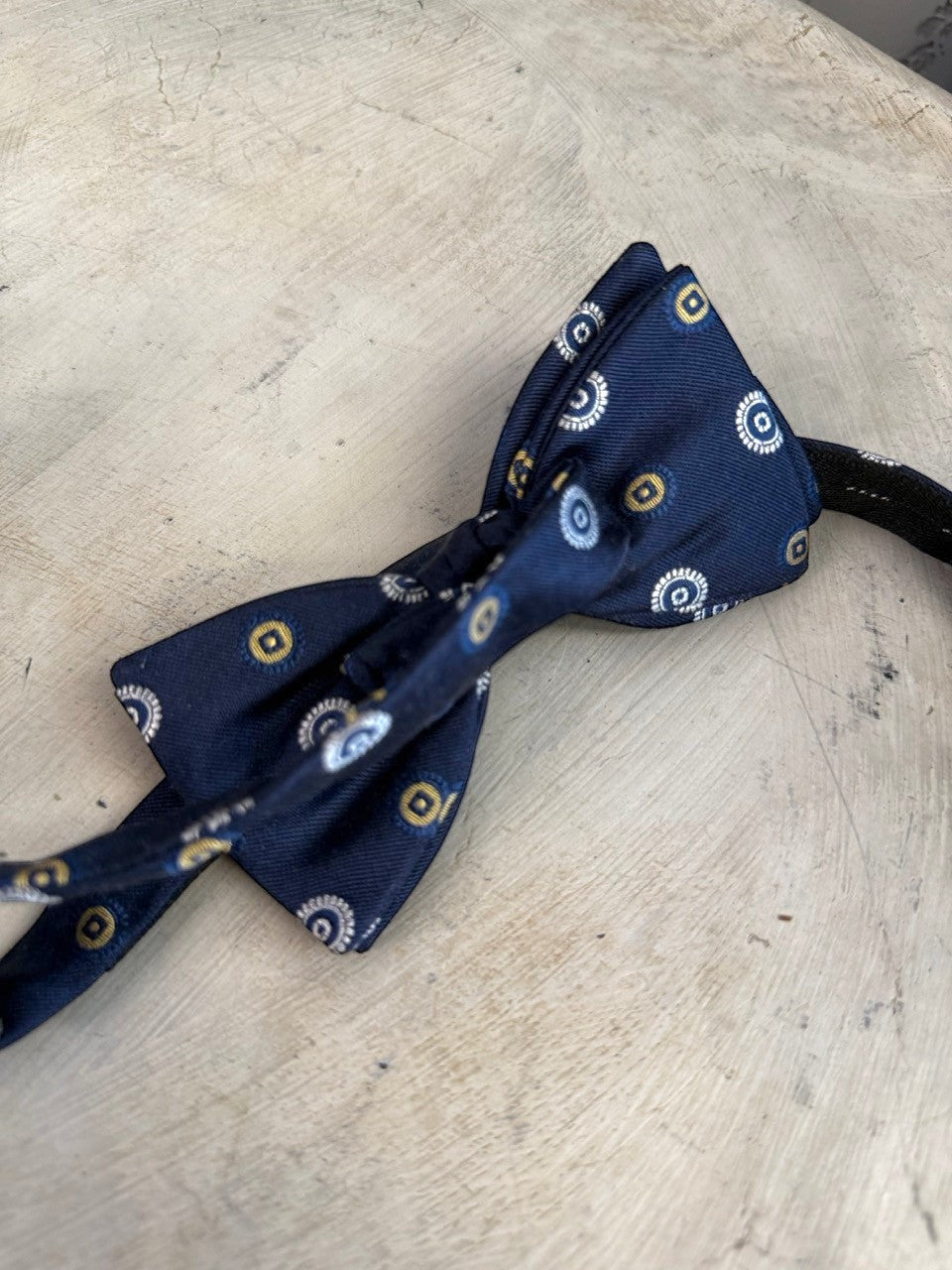 BERLIN VINTAGE CORNER navy blue pre-tied bow tie with white and gold concentric circle pattern. Adjustable strap.