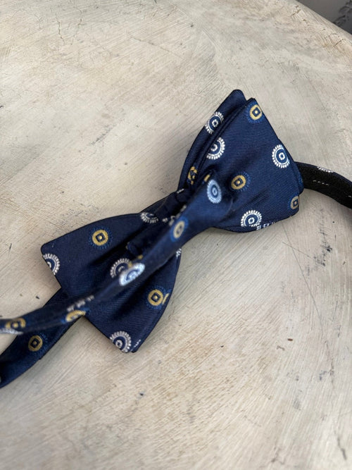 BERLIN VINTAGE CORNER navy blue pre-tied bow tie with white and gold concentric circle pattern. Adjustable strap.