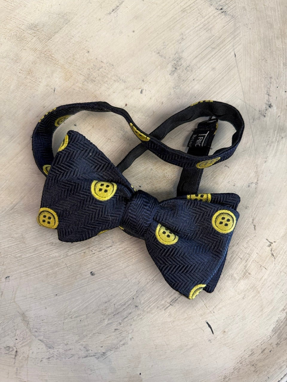 BERLIN VINTAGE CORNER navy blue bow tie with yellow button pattern and herringbone texture. Adjustable strap.
