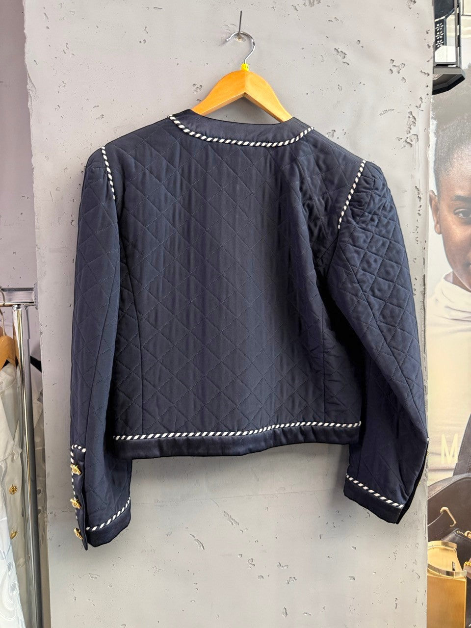 BERLIN VINTAGE CORNER navy quilted jacket with white piping, jeweled buttons, and puffed shoulders.