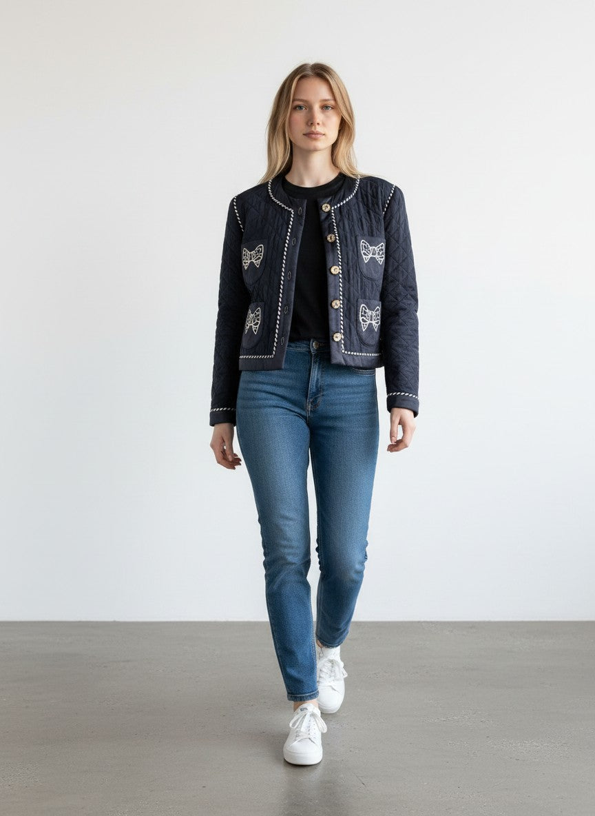 BERLIN VINTAGE CORNER navy quilted jacket with white piping, jeweled buttons, and embroidered bow appliques on pockets.