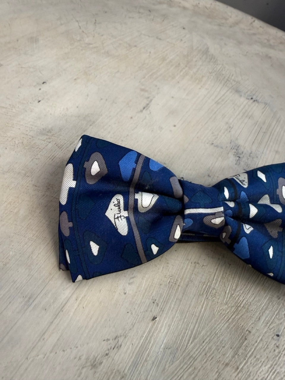 BERLIN VINTAGE CORNER navy blue silk bow tie with white, grey, and blue card suit pattern and thin border.