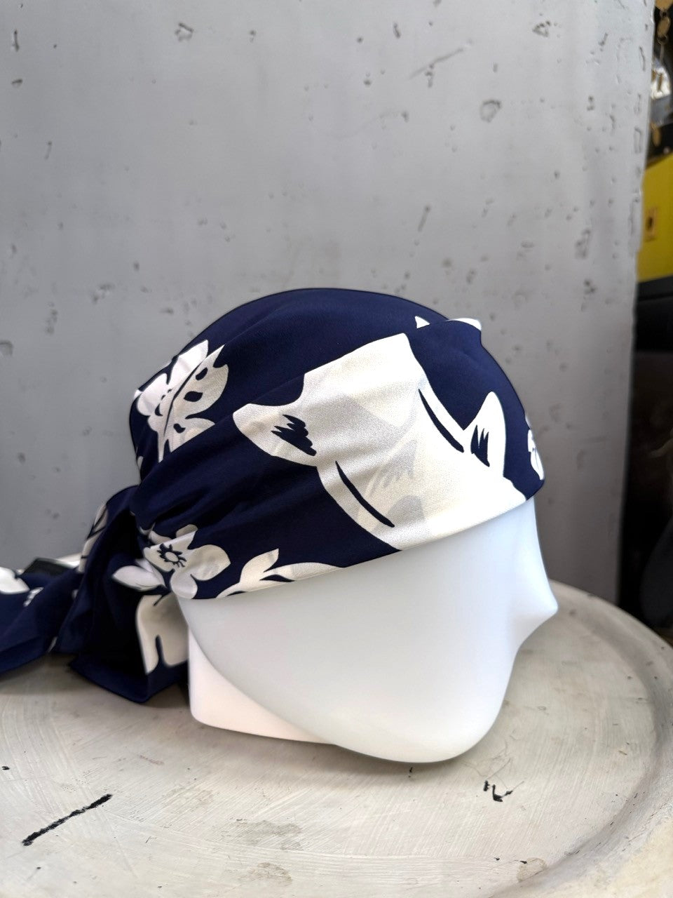 BERLIN VINTAGE CORNER navy blue silk scarf with white floral and dolphin print styled as a headscarf on a mannequin