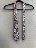 Nicole Miller 1992 black 100% silk necktie with a collage print of envelopes, stamps, and landmarks.