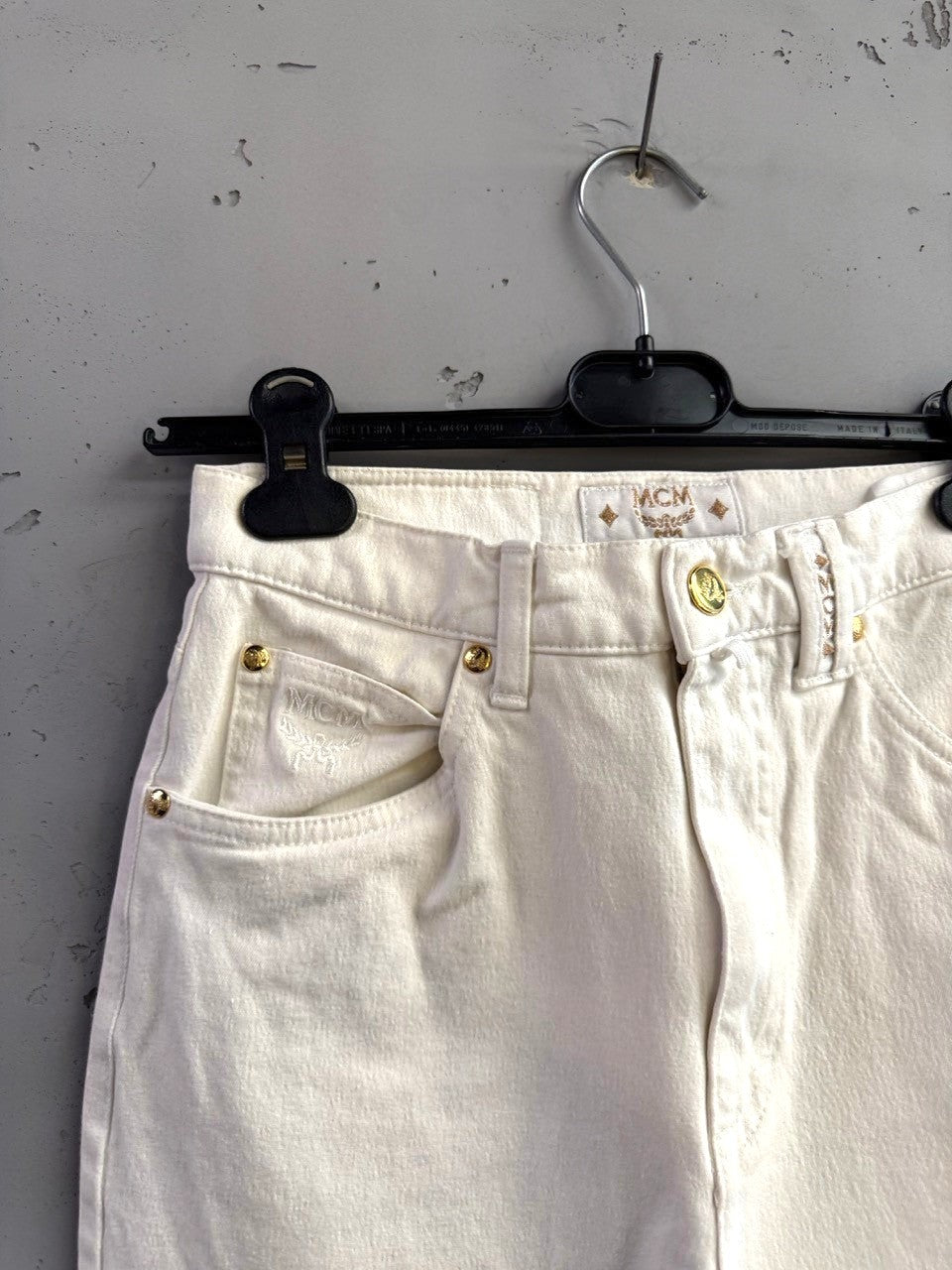 BERLIN VINTAGE CORNER off-white straight leg jeans with gold-tone hardware and MCM logo detail.