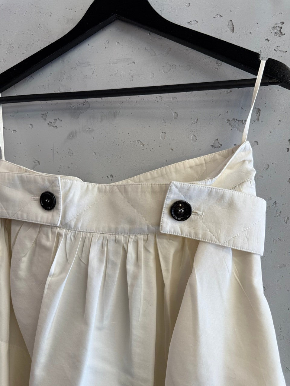BERLIN VINTAGE CORNER off-white pleated skirt with quilted waistband and black button details.
