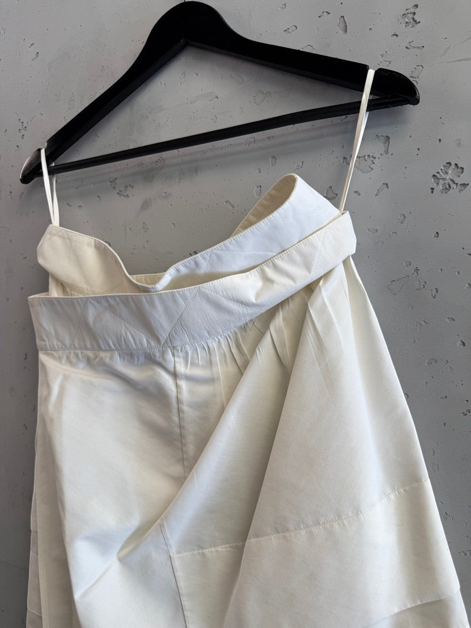 BERLIN VINTAGE CORNER off-white pleated skirt with quilted waistband and black button details.