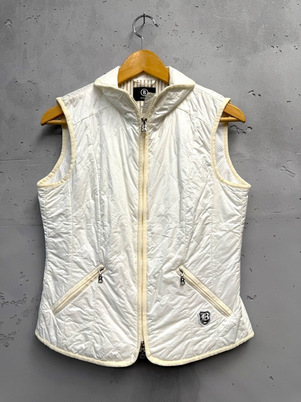 BERLIN VINTAGE CORNER off-white quilted padded vest with zip front, stand-up collar, and zippered pockets.