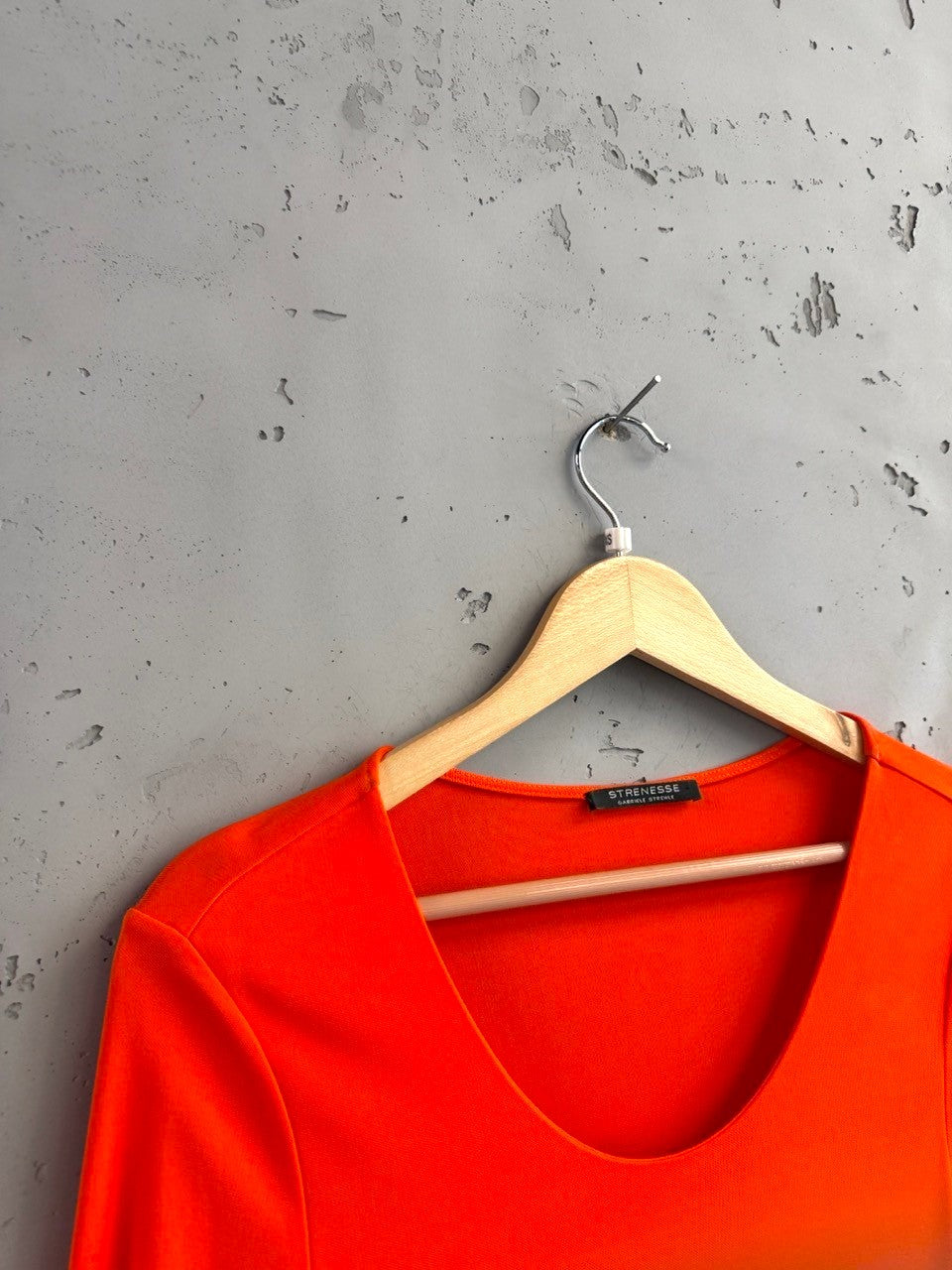 BERLIN VINTAGE CORNER vibrant orange stretchy long sleeve top with a scoop neck and subtle side seam detail.