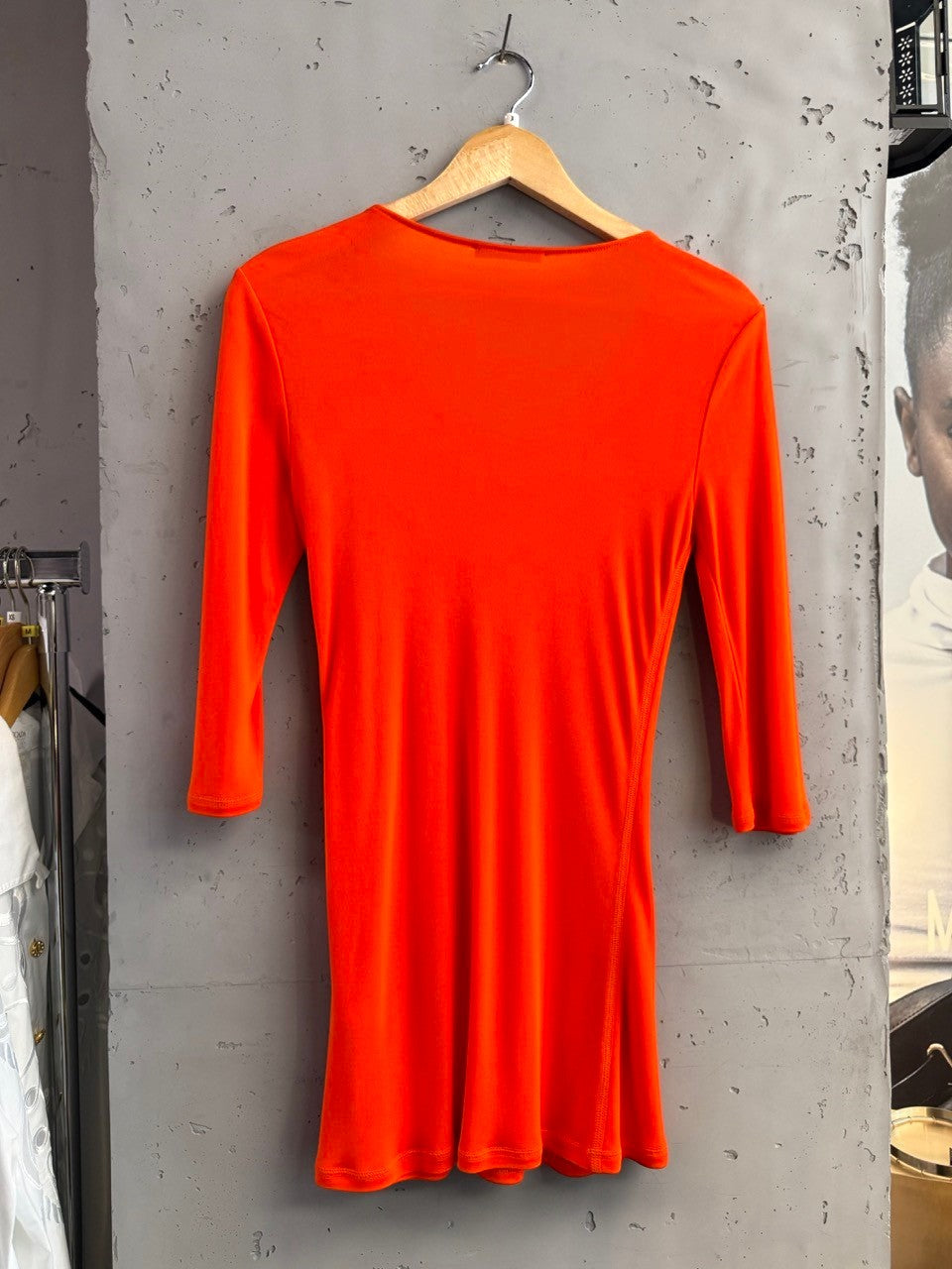 BERLIN VINTAGE CORNER vibrant orange stretchy long sleeve top with three-quarter sleeves and side seam detail.