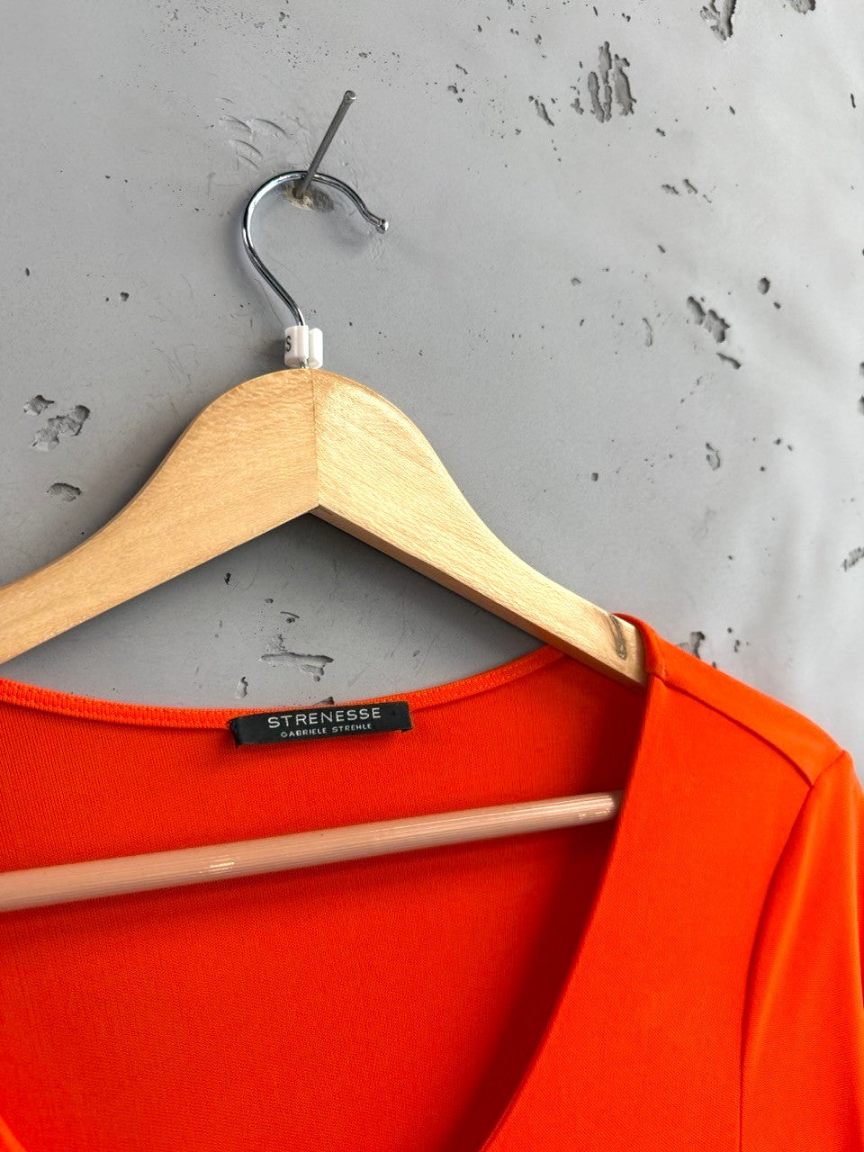 BERLIN VINTAGE CORNER vibrant orange long sleeve top with a flattering silhouette and subtle side seam detail.
