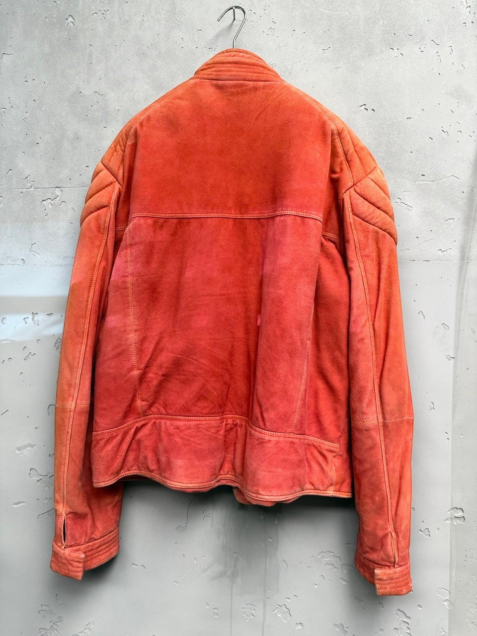 BERLIN VINTAGE CORNER orange suede moto jacket with quilted detailing on shoulders and sleeves.