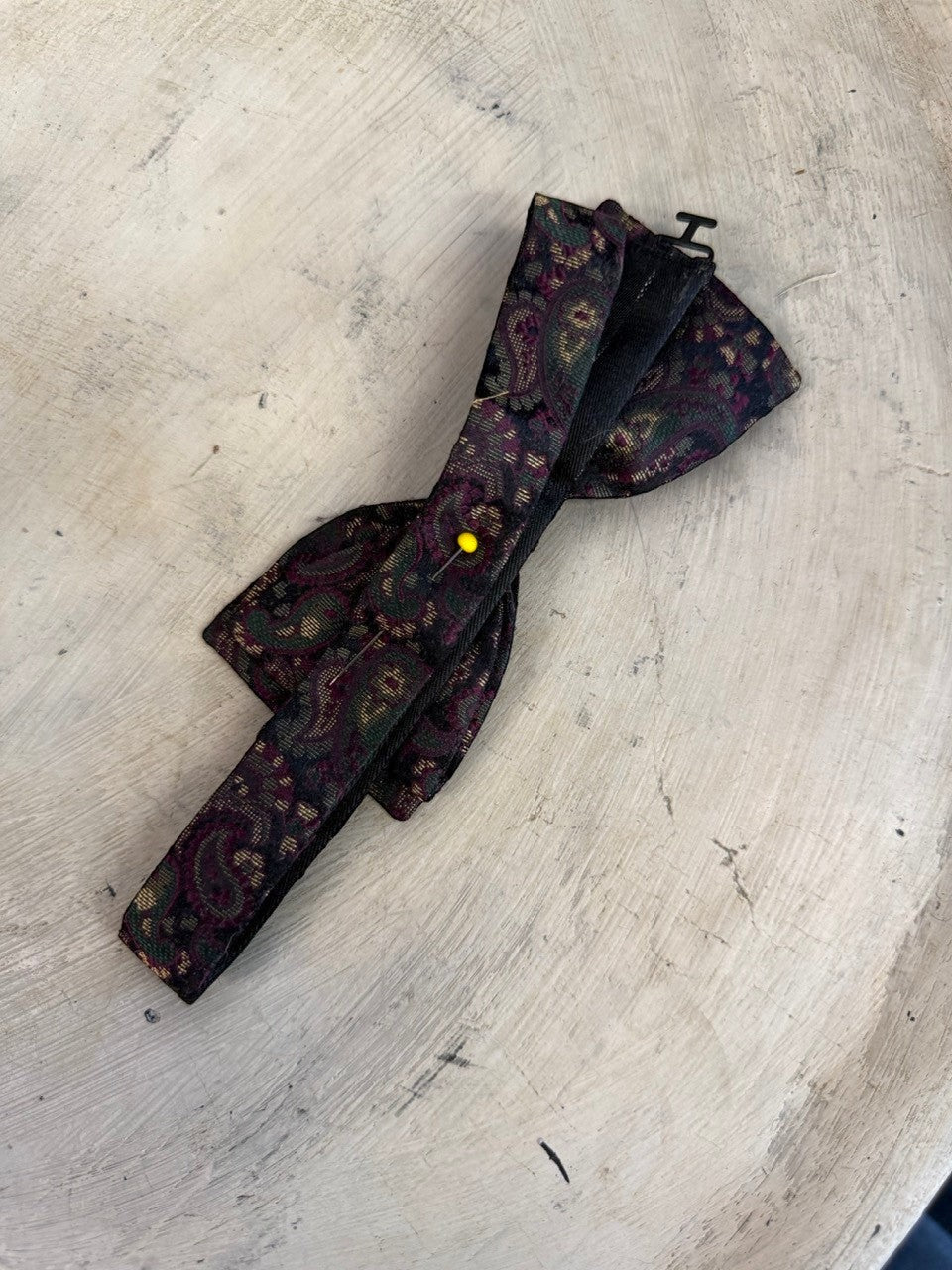 BERLIN VINTAGE CORNER paisley patterned silk bow tie in burgundy, forest green, and gold on a dark background. Adjustable strap.