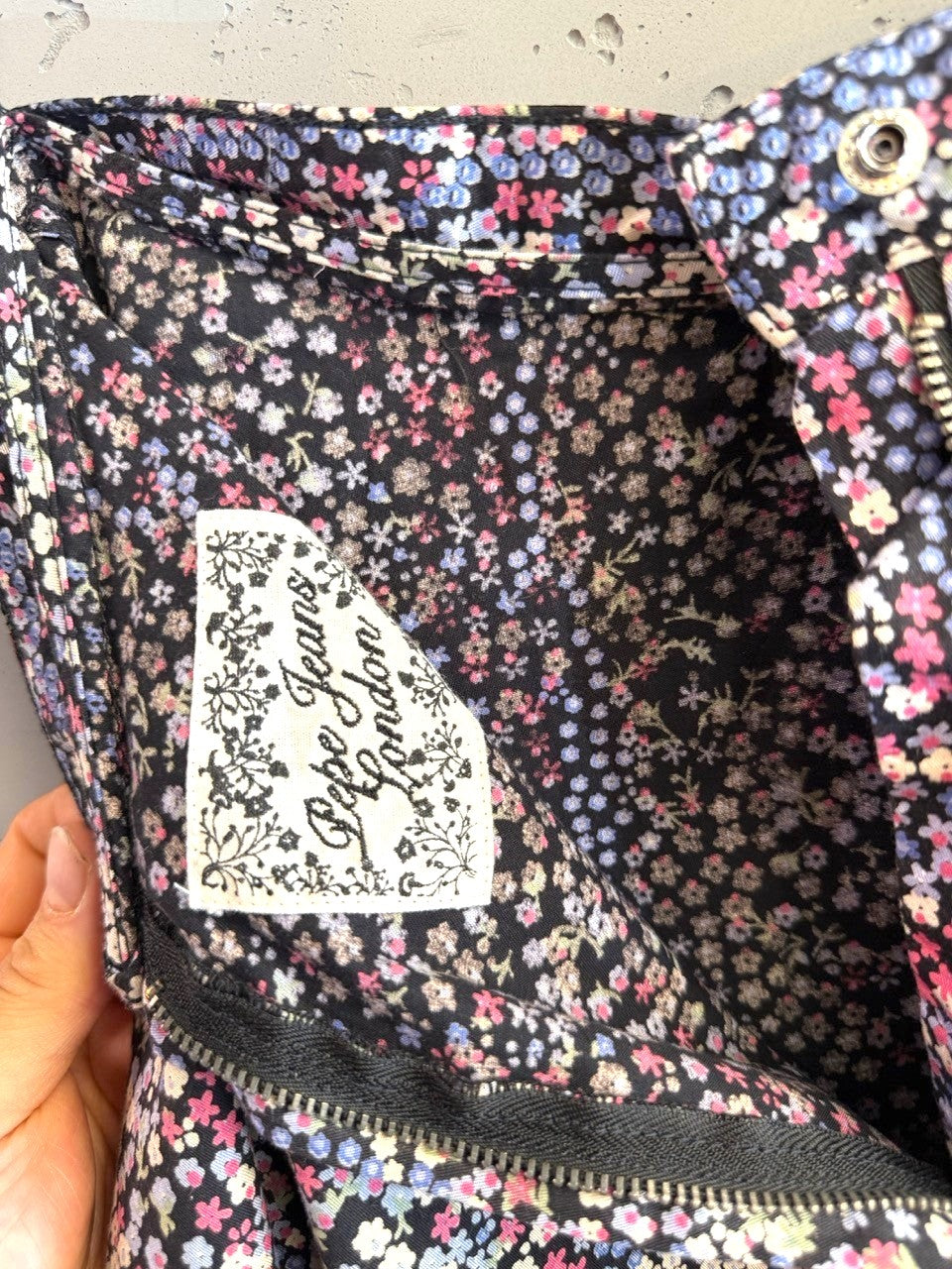 BERLIN VINTAGE CORNER Pepe Jeans London black mini skirt with pink, blue, and white ditsy floral print. Features a zipper closure.