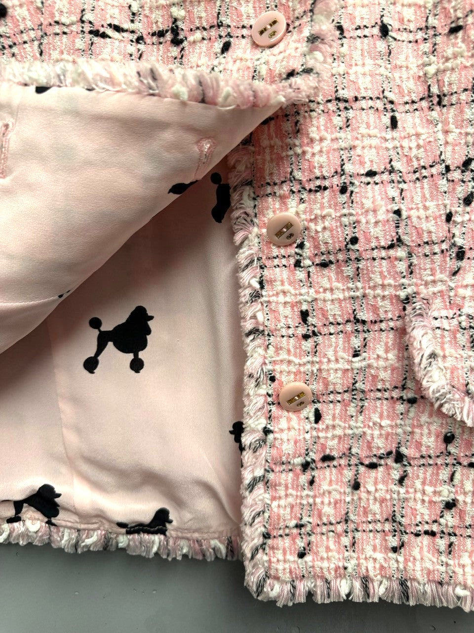 BERLIN VINTAGE CORNER pink tweed jacket with black and white plaid pattern, frayed trim, and poodle print lining.