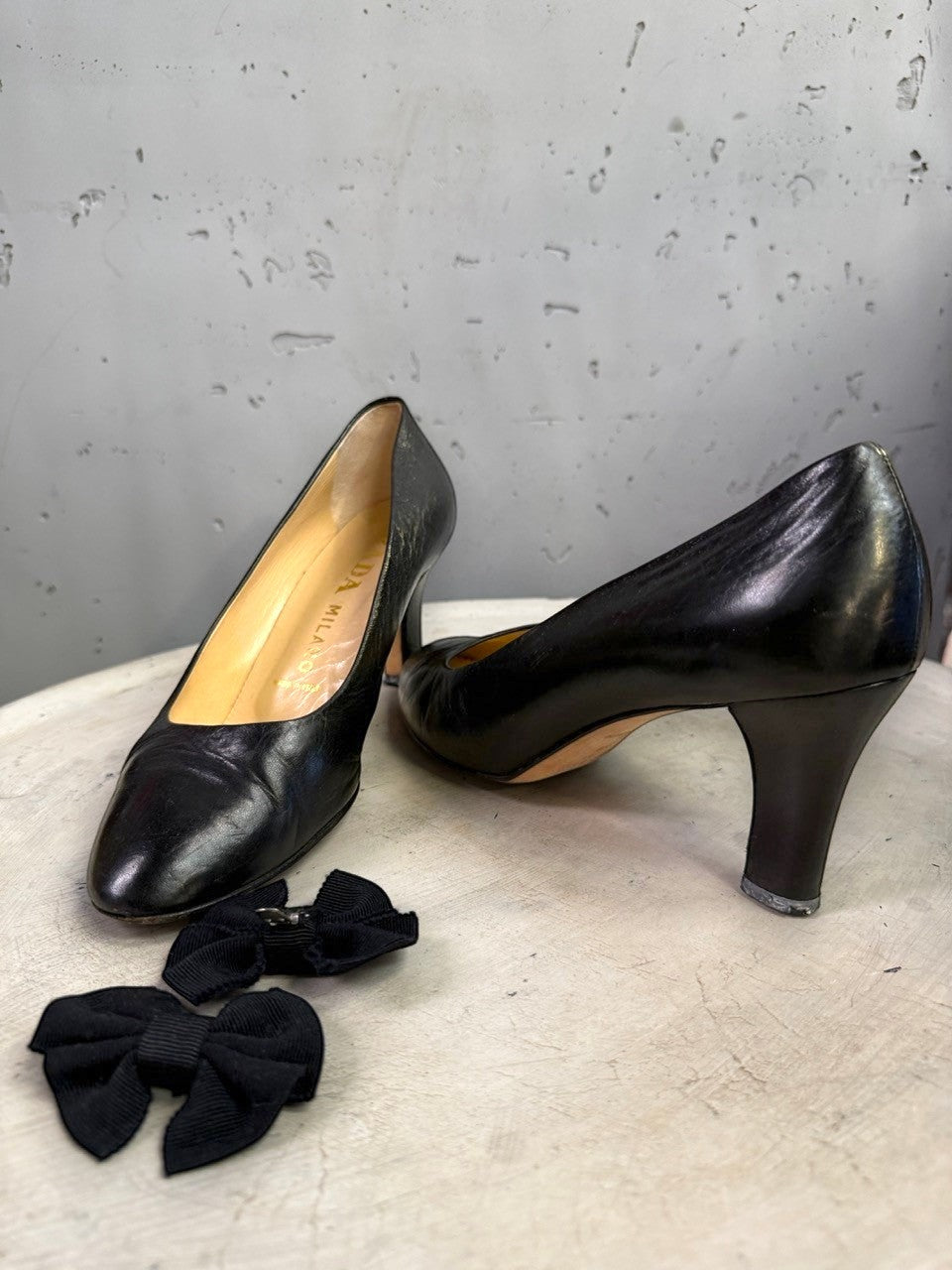 BERLIN VINTAGE CORNER Prada black leather almond-toe pumps with mid-height heels and bow accents.