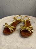 BERLIN VINTAGE CORNER Prada metallic gold leather flat sandals with delicate bow detail and brown leather footbed.