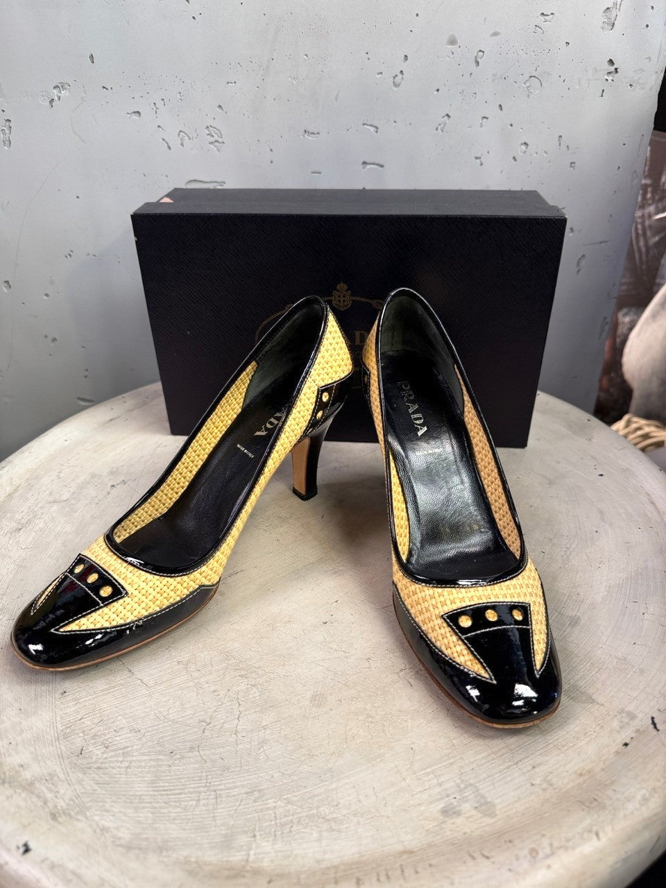 BERLIN VINTAGE CORNER Prada pumps in woven raffia and black patent leather with stud detailing and mid-height heels.