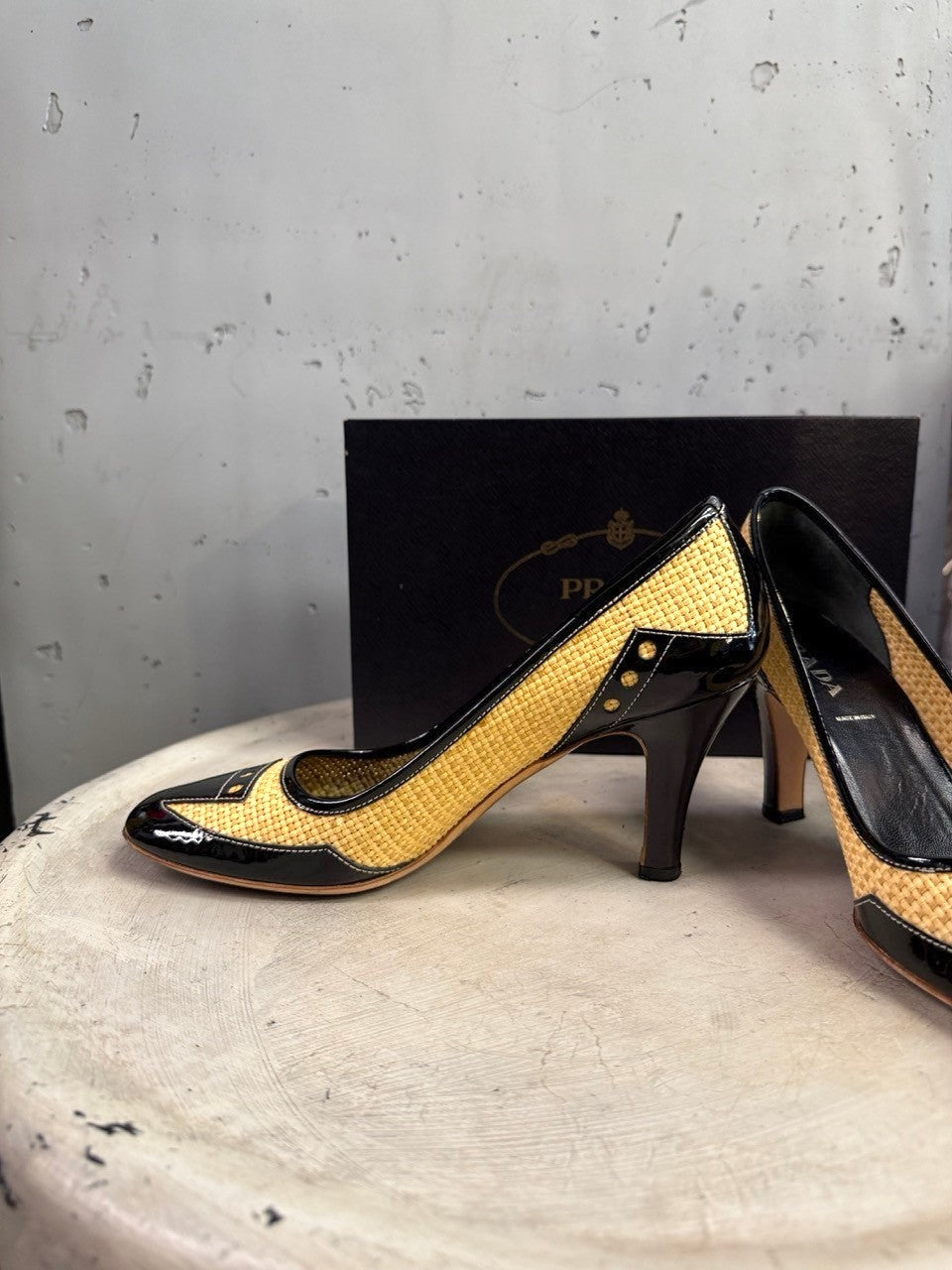 BERLIN VINTAGE CORNER Prada pumps in woven raffia and black patent leather with stud details and mid-height heels.