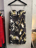 BERLIN VINTAGE CORNER sleeveless midi cocktail dress with abstract black, white, and gold print and deep-V neckline.