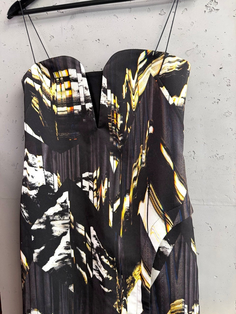 BERLIN VINTAGE CORNER sleeveless midi cocktail dress with abstract black, white, and gold print and deep V-neckline.