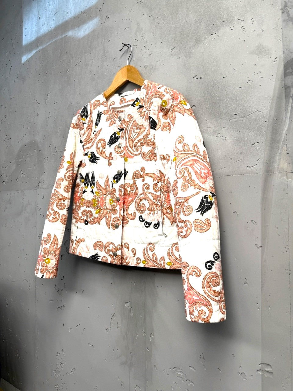 BERLIN VINTAGE CORNER quilted jacket with paisley and floral print in pink, black, and yellow on white. Round neckline, button front.