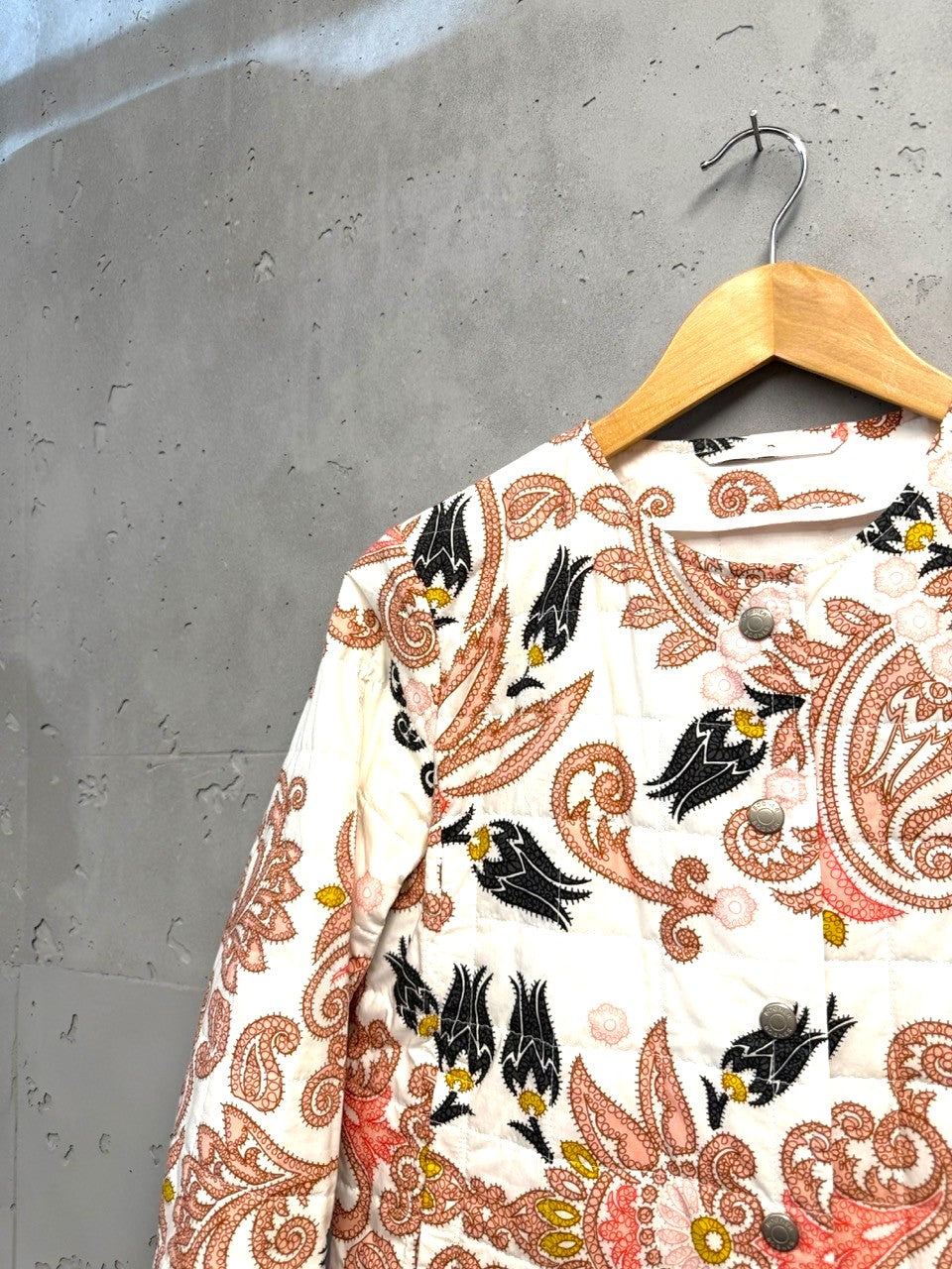 BERLIN VINTAGE CORNER quilted jacket with paisley and floral print in pink, black, and yellow on white. Round neckline, button front.