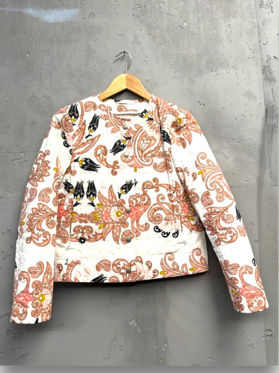 BERLIN VINTAGE CORNER quilted jacket with pink, black, and yellow paisley floral print on white. Round neckline, button front.