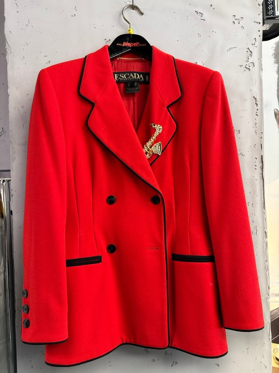 BERLIN VINTAGE CORNER red wool blend double-breasted blazer with black piping and buttons, featuring a jeweled saxophone brooch.