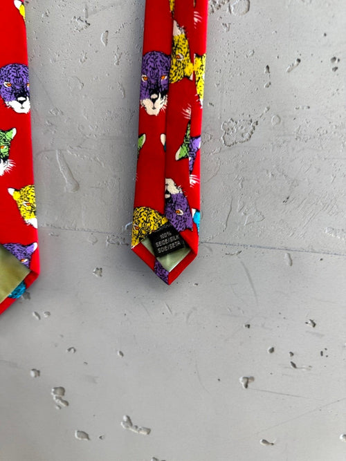 BERLIN VINTAGE CORNER red silk tie with a bold jaguar print in purple, yellow, green, and blue.