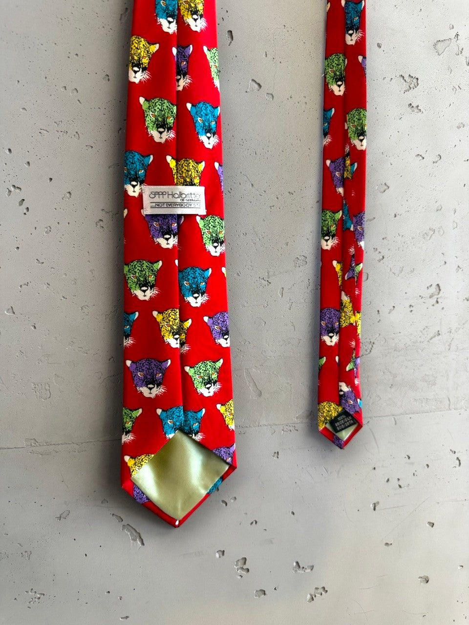 BERLIN VINTAGE CORNER red silk tie with a bold jaguar print in purple, yellow, green, and blue.