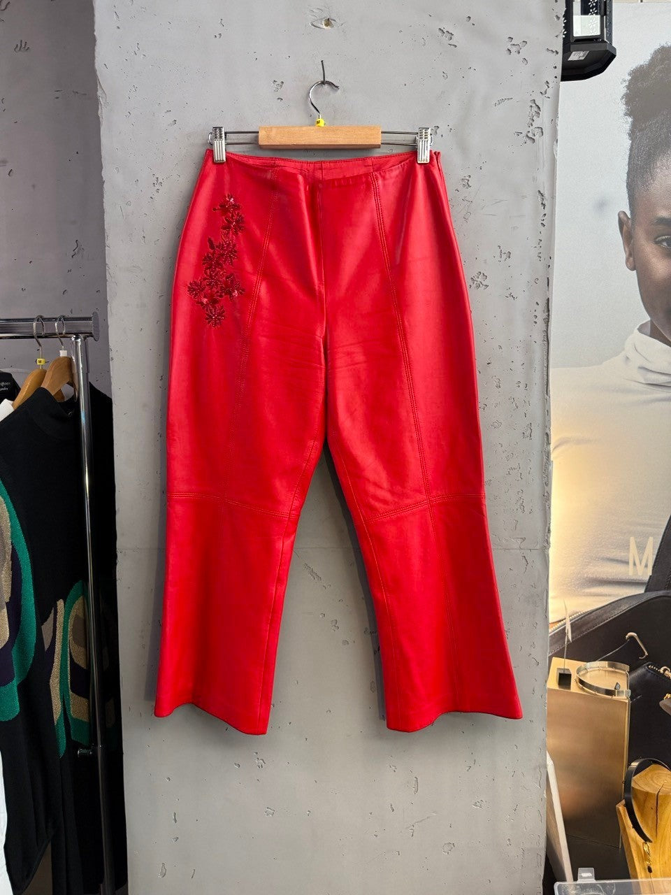 BERLIN VINTAGE CORNER red leather cropped pants with floral embellishment on left hip. Flared leg.