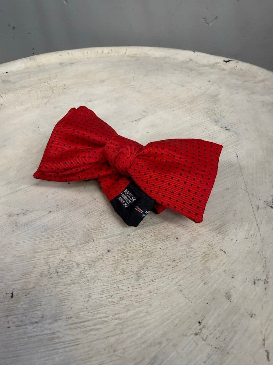 BERLIN VINTAGE CORNER red 100% silk bow tie with black polka dots and adjustable strap.