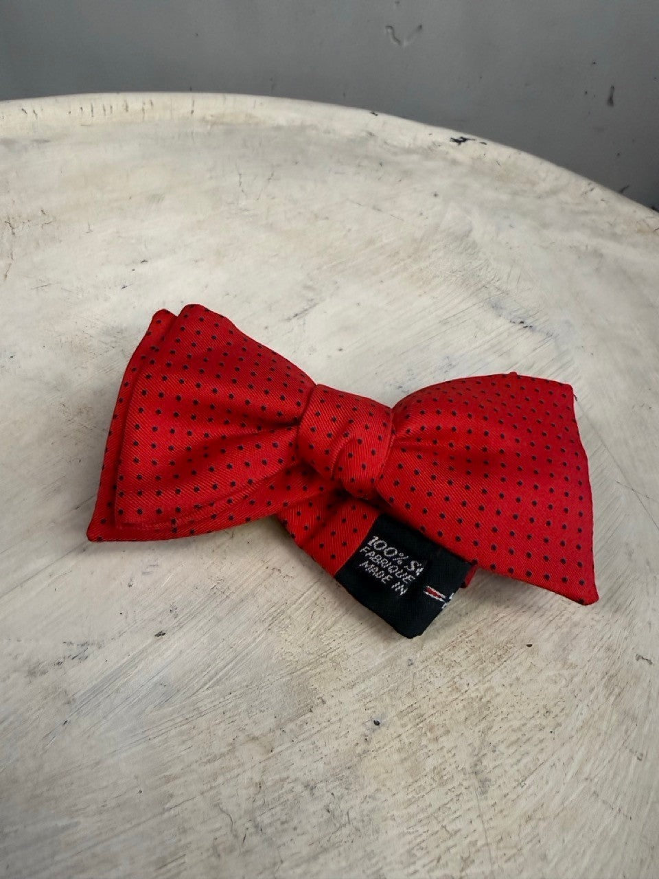 BERLIN VINTAGE CORNER red 100% silk bow tie with black polka dots and adjustable strap.